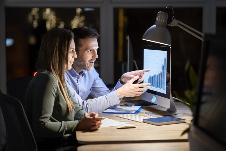 caucasian woman man working late together office